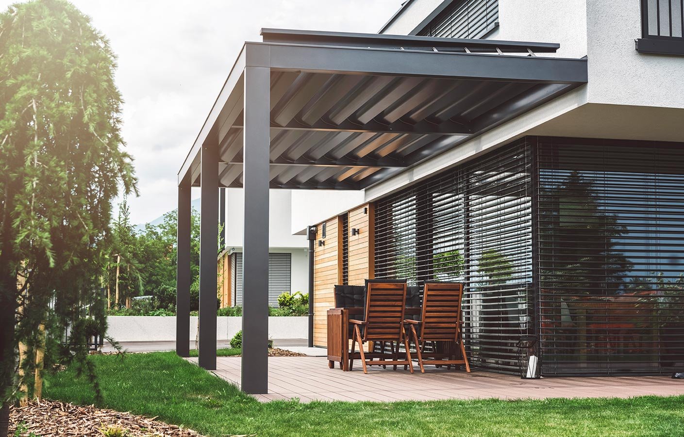 Moderne Terrassenüberdachung als Pergola an einem Einfamilienhaus