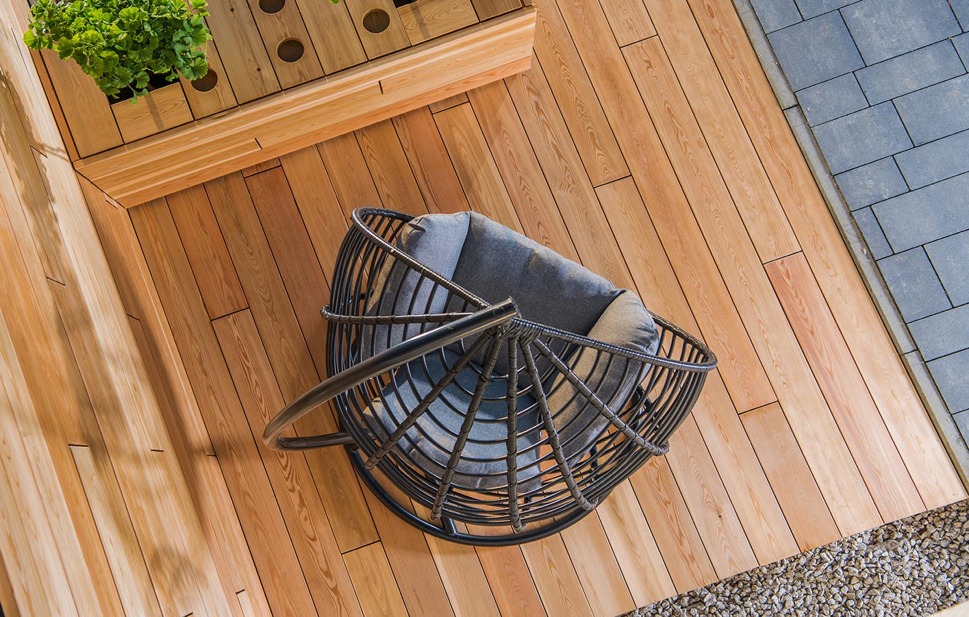 Blick von oben auf einen Teil einer Terrasse mit Holz und einem Sessel von oben