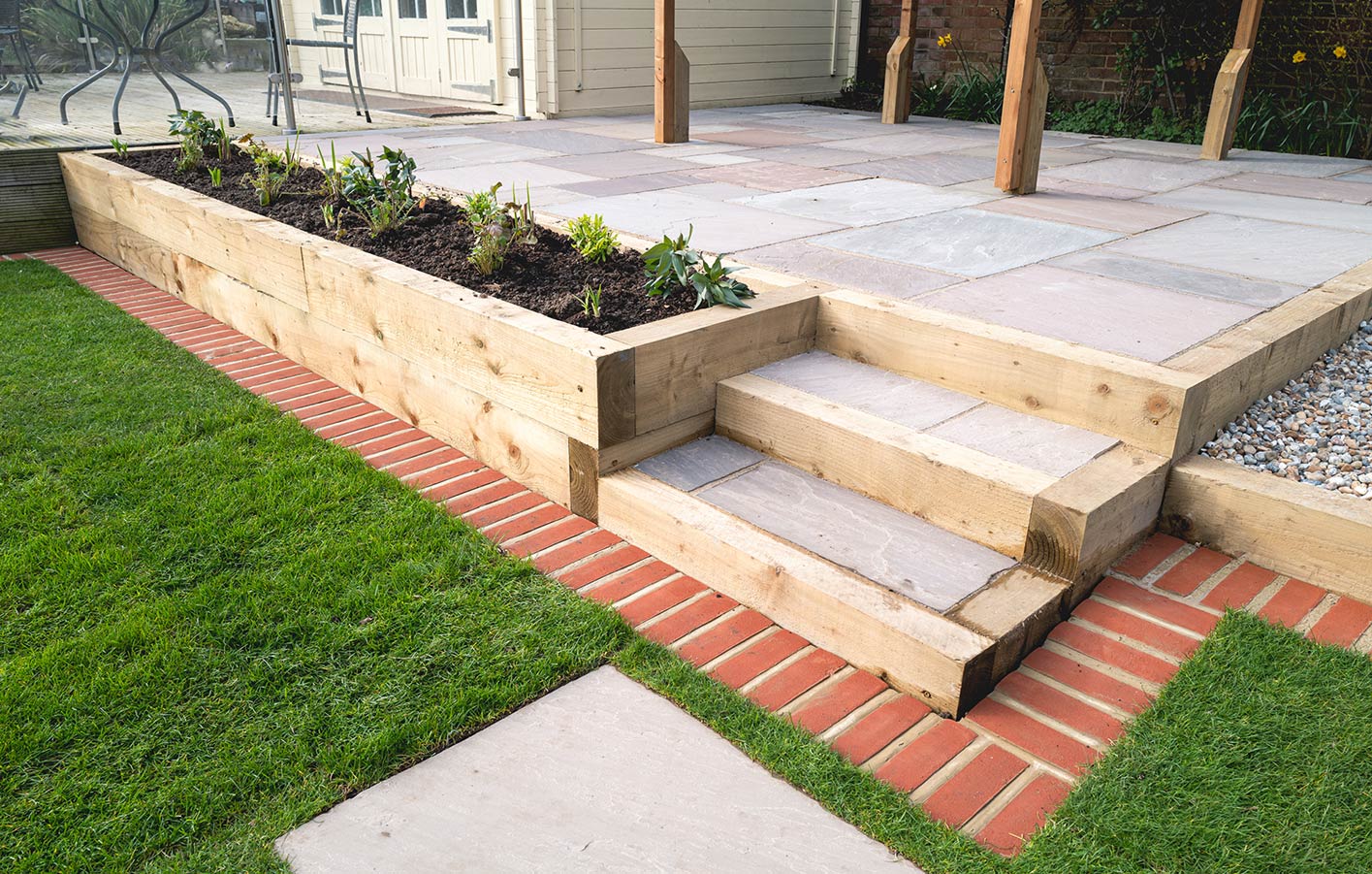 Hochbeet an der Terrasse und Treppen mit Gartenholz